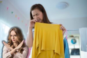 donna che sente puzza sui vestiti e un'altra che fa stop con le mani