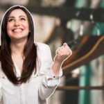 donna che esulta e grucce appese come sfondo