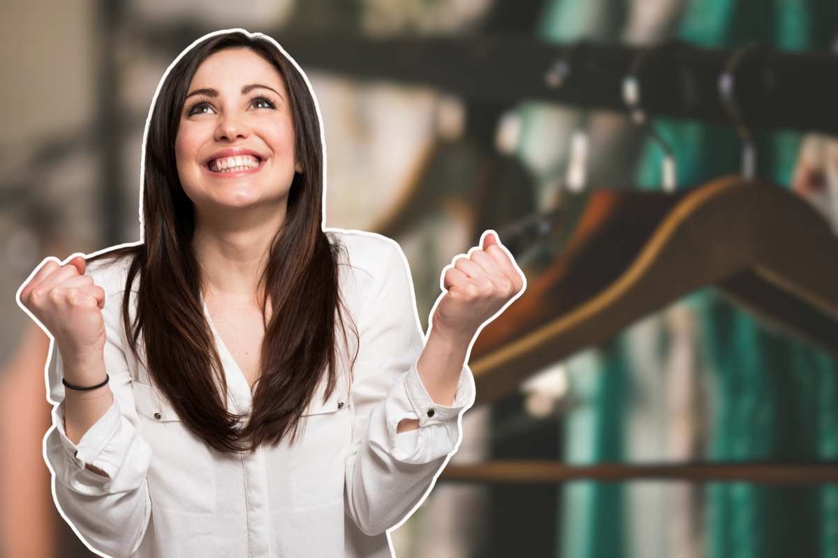 donna che esulta e grucce appese come sfondo